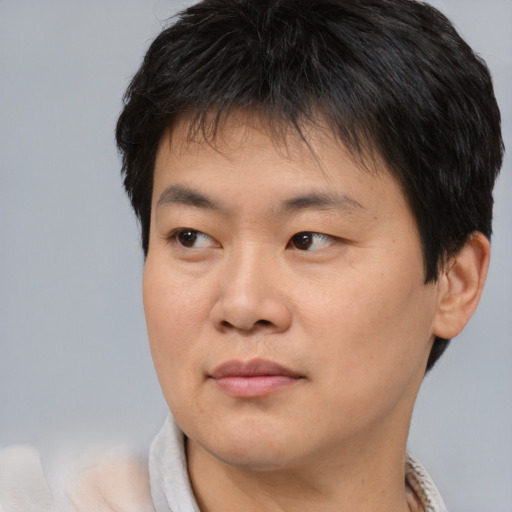Joyful asian young-adult male with short  brown hair and brown eyes