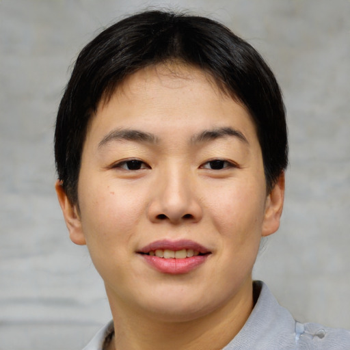 Joyful asian young-adult female with short  brown hair and brown eyes