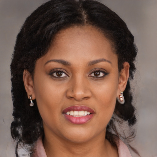 Joyful black young-adult female with long  brown hair and brown eyes
