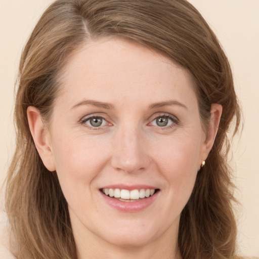 Joyful white young-adult female with long  brown hair and grey eyes