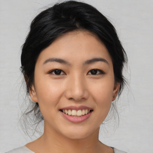 Joyful asian young-adult female with medium  black hair and brown eyes