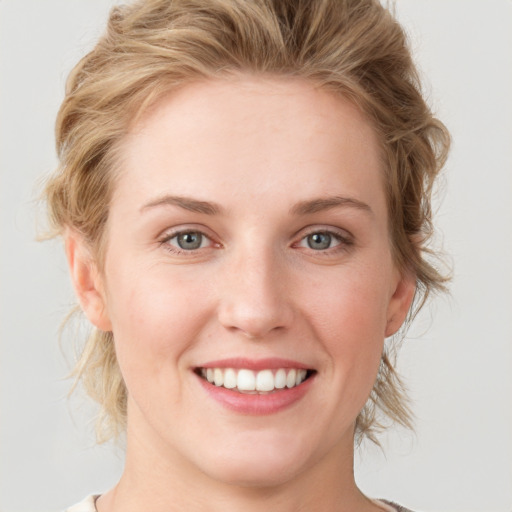 Joyful white young-adult female with medium  brown hair and blue eyes