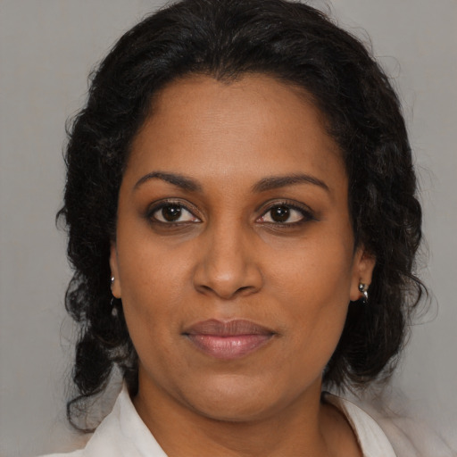 Joyful black adult female with medium  brown hair and brown eyes