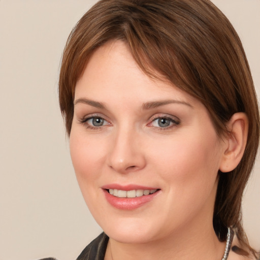 Joyful white young-adult female with medium  brown hair and grey eyes