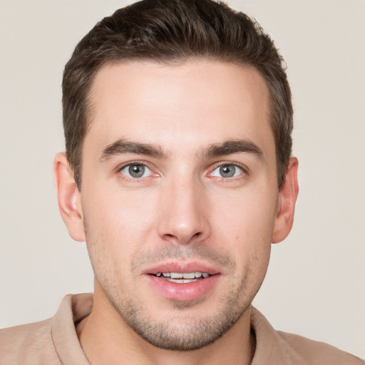 Joyful white young-adult male with short  brown hair and grey eyes