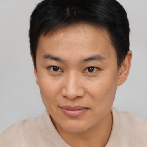 Joyful asian young-adult male with short  brown hair and brown eyes