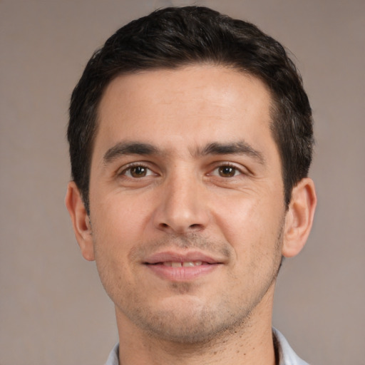 Joyful white young-adult male with short  black hair and brown eyes