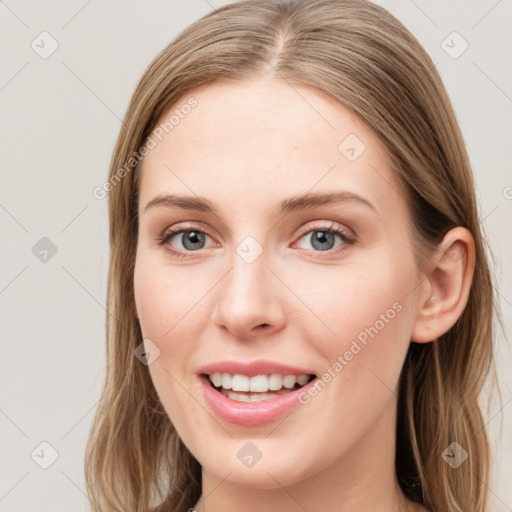 Joyful white young-adult female with long  brown hair and blue eyes