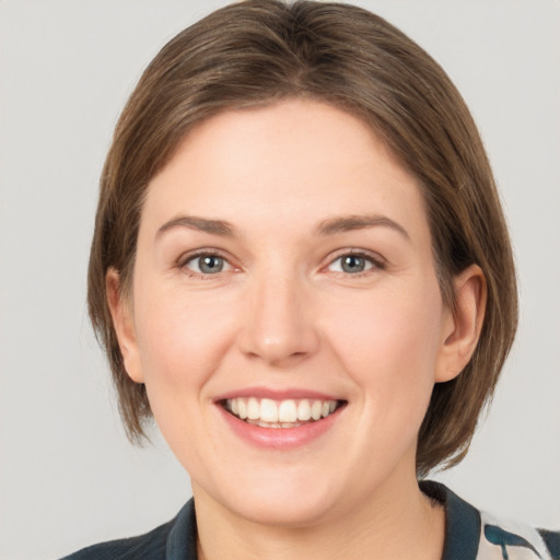 Joyful white young-adult female with medium  brown hair and grey eyes