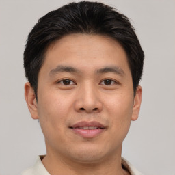 Joyful asian young-adult male with short  brown hair and brown eyes