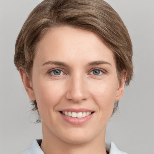 Joyful white young-adult female with medium  brown hair and grey eyes