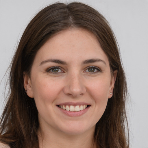 Joyful white young-adult female with long  brown hair and brown eyes