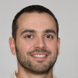 Joyful white young-adult male with short  brown hair and brown eyes