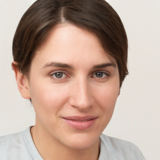 Joyful white young-adult female with short  brown hair and brown eyes