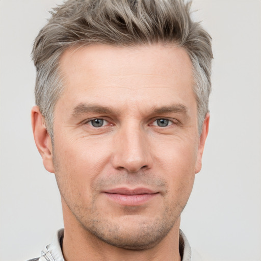 Joyful white adult male with short  brown hair and grey eyes