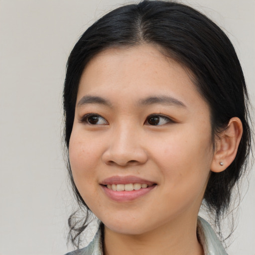 Joyful asian young-adult female with medium  black hair and brown eyes