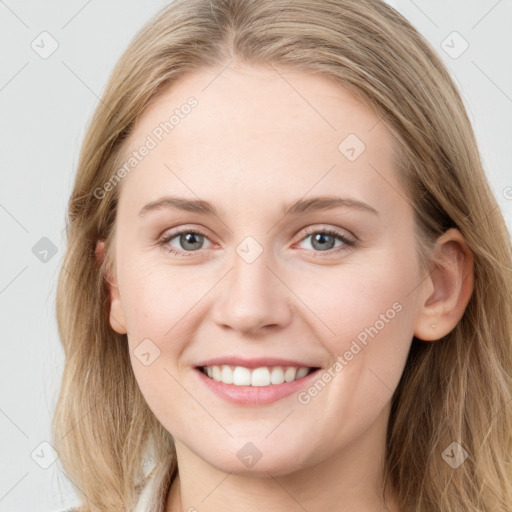 Joyful white young-adult female with long  brown hair and blue eyes