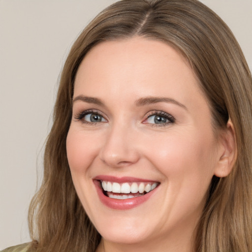 Joyful white young-adult female with long  brown hair and grey eyes