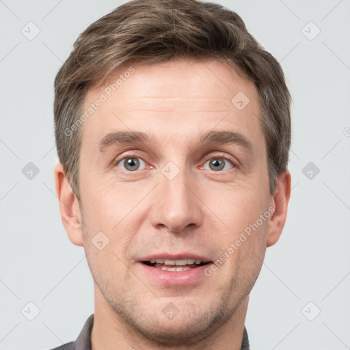 Joyful white young-adult male with short  brown hair and grey eyes