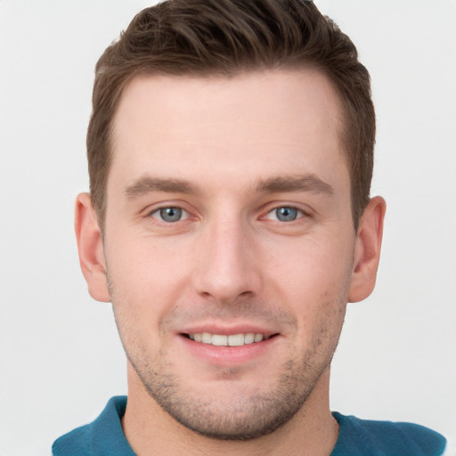 Joyful white young-adult male with short  brown hair and grey eyes