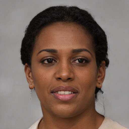 Joyful black young-adult female with short  brown hair and brown eyes