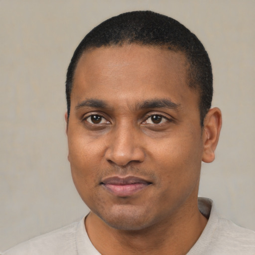 Joyful black young-adult male with short  black hair and brown eyes