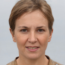 Joyful white adult female with short  brown hair and grey eyes