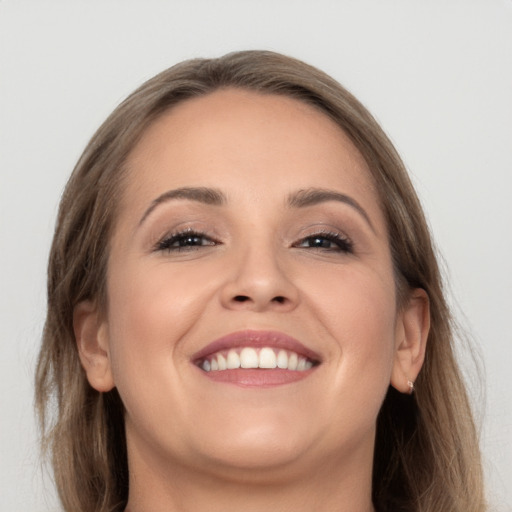 Joyful white young-adult female with long  brown hair and brown eyes