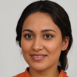 Joyful latino young-adult female with medium  brown hair and brown eyes