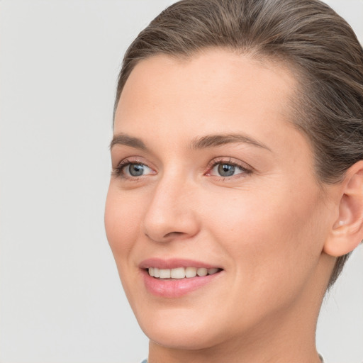 Joyful white young-adult female with short  brown hair and grey eyes