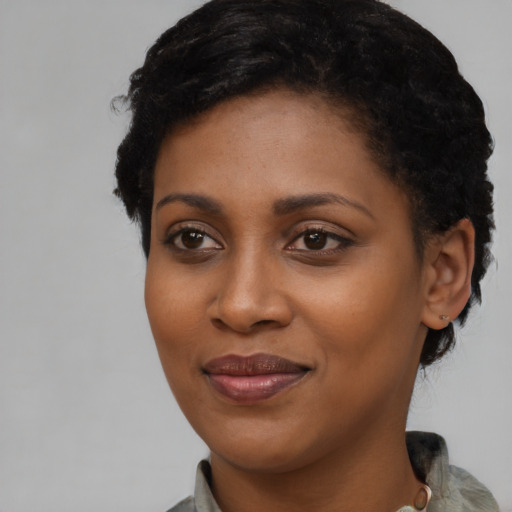 Joyful black young-adult female with short  brown hair and brown eyes