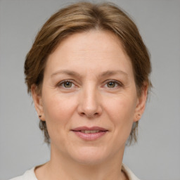 Joyful white adult female with medium  brown hair and grey eyes