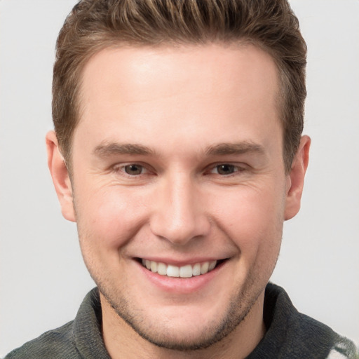 Joyful white young-adult male with short  brown hair and grey eyes