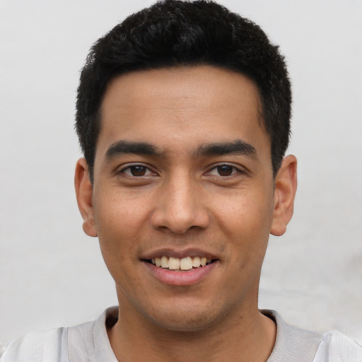 Joyful latino young-adult male with short  black hair and brown eyes