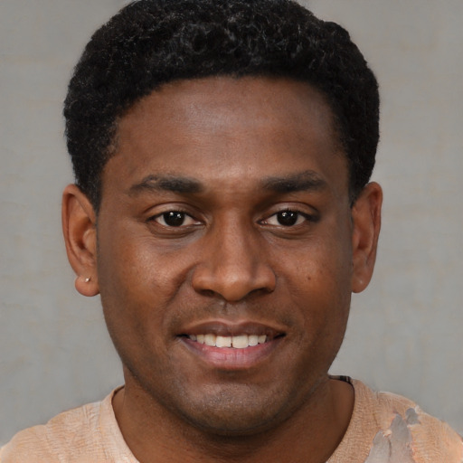 Joyful black young-adult male with short  black hair and brown eyes