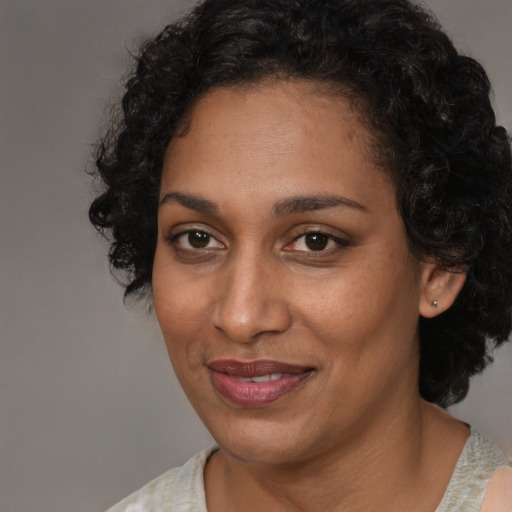 Joyful black adult female with short  brown hair and brown eyes