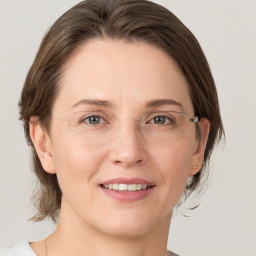 Joyful white adult female with medium  brown hair and grey eyes