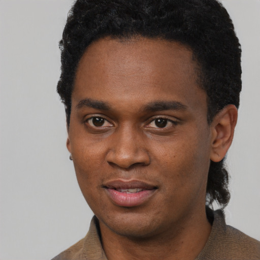 Joyful black young-adult male with short  black hair and brown eyes