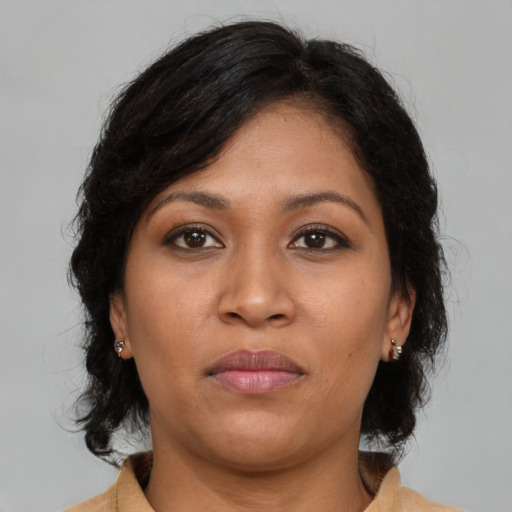 Joyful latino adult female with medium  brown hair and brown eyes