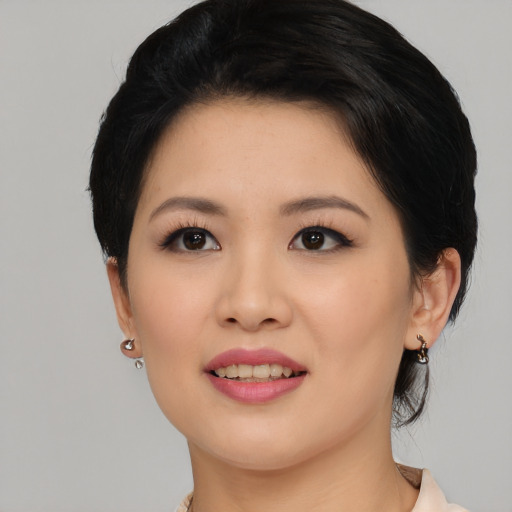 Joyful asian young-adult female with medium  black hair and brown eyes