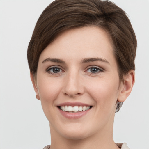 Joyful white young-adult female with short  brown hair and grey eyes