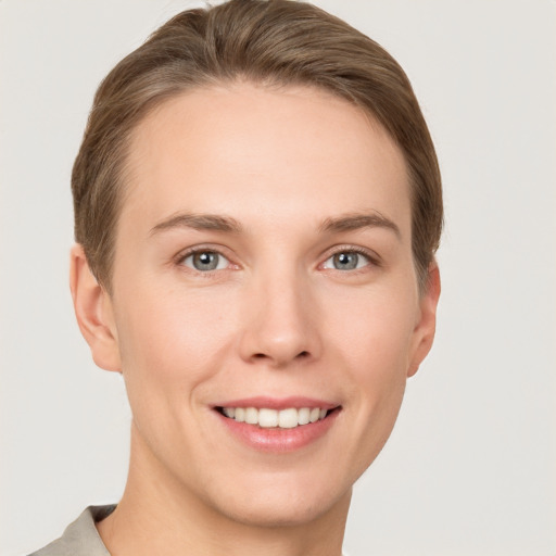 Joyful white young-adult female with short  brown hair and grey eyes