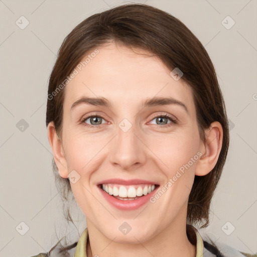 Joyful white young-adult female with medium  brown hair and grey eyes