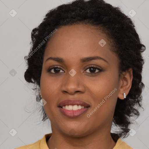 Joyful black young-adult female with long  brown hair and brown eyes