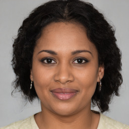 Joyful black young-adult female with medium  brown hair and brown eyes