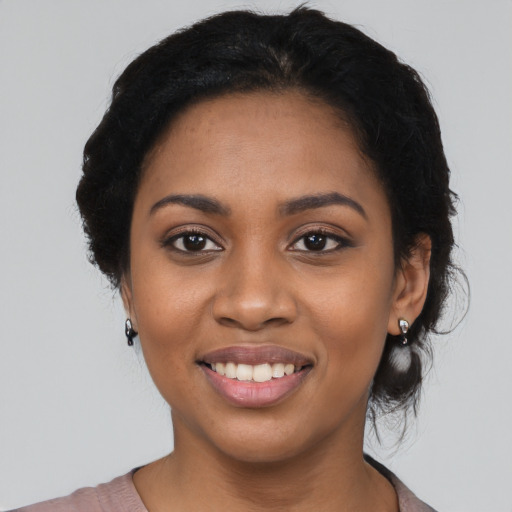 Joyful black young-adult female with medium  black hair and brown eyes