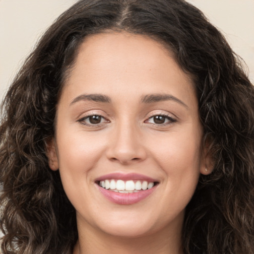 Joyful white young-adult female with long  brown hair and brown eyes