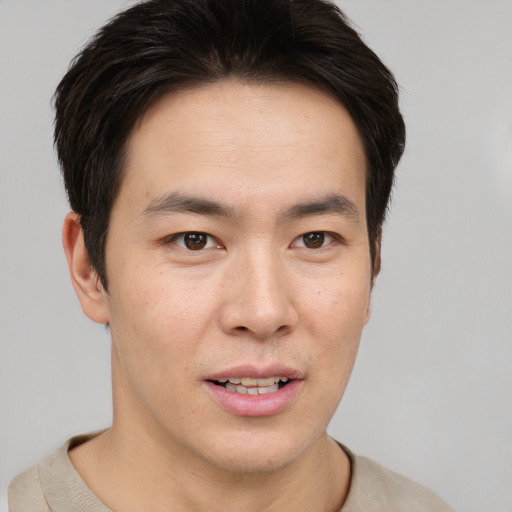Joyful asian young-adult male with short  brown hair and brown eyes