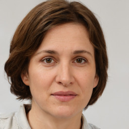 Joyful white adult female with medium  brown hair and grey eyes