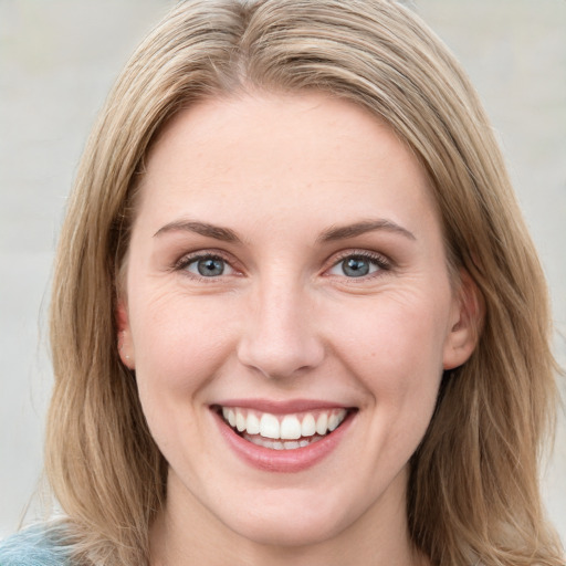 Joyful white young-adult female with long  brown hair and blue eyes